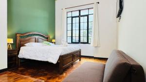 a bedroom with a bed and a couch and a window at 1825 Hotel in La Paz
