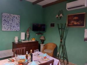 a dining room with a table and a tv at Holiday Maison Villa Arci in Giardini Naxos