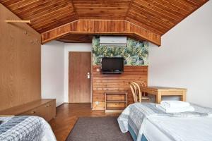 una camera da letto con due letti e una TV a parete di Willa Pierrot a Oświęcim