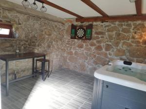 a bathroom with a tub and a table and a clock at Holiday House Marija in Otočac +37 photos