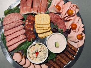 a plate of food with different types of meats and cheese at Conacul Coroanei Luxury Boutique in Bucharest
