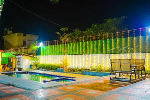 a bench in front of a fence with green lights at Maneva Comforts in Mangalore