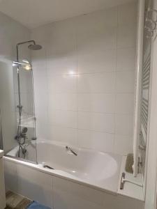 a white bathroom with a tub and a shower at Bel apartment - Waterloo in Waterloo