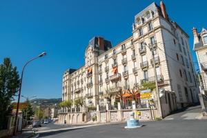 a large white building on a street with a street light at Confortable studio meublé classé 3 étoiles in Châtel-Guyon