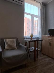 a bedroom with a bed and a table and a window at Dārza Studija in Limbaži +6 photos