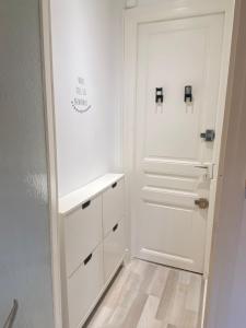 a white hallway with a white door and a white cabinet at Confortable studio meublé classé 3 étoiles in Châtel-Guyon