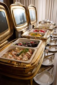 a buffet with several trays of food on a table at Crona SPA Karpaty in Skhidnitsa