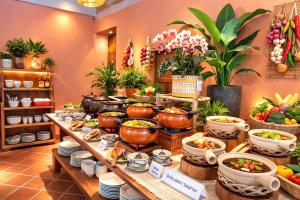 a buffet with pots and pans of food and plants at FORTUNE HOTEL 2 LUCKY STAY Phu Quoc in Phú Quốc