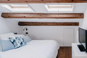 a bedroom with a white bed and skylights at Domus Silvana Apartments in Ravenna
