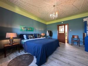 a bedroom with a bed with a blue bedspread at Logie By Dedes in Birchiş