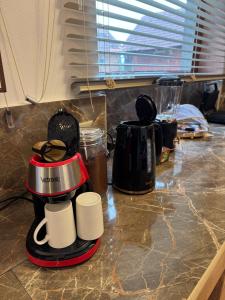 a counter with two coffee pots and cups on it at Logie By Dedes in Birchiş +45 photos