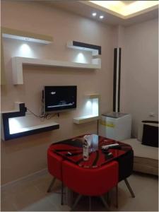 a living room with a red chair and a table at الغردقة - اول ممشى شيرى in Hurghada +4 photos