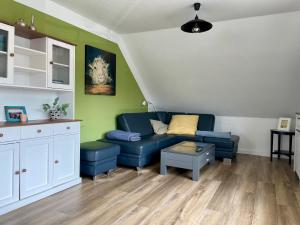 a living room with a blue couch and a table at Ferienwohnung Dümmerling in Hüde in Hüde