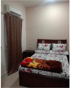 a bedroom with a bed with a blanket and pillows at الغردقة - اول ممشى شيرى in Hurghada