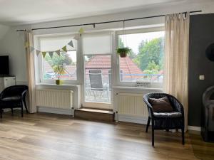 a living room with two windows and a chair at Ferienwohnung Dümmerling in Hüde in Hüde