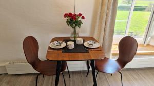 a table with chairs and a vase of flowers on it at Au Bourg in Le Landeron
