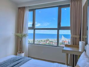 a bedroom with a large window with a view of the ocean at Căn hộ The Sóng Vũng Tàu Infinity Pool - Near Sea Tháp Tam Thắng in Vung Tau
