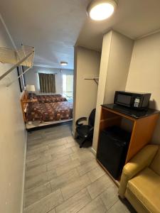 a room with a bed and a desk with a laptop at Park Motel in Tampa