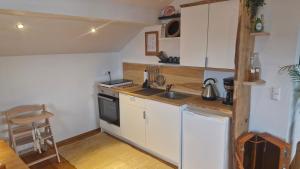 a small kitchen with white cabinets and a sink at Ferienwohnung am Bühl in Cham