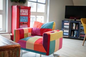 a colorful striped chair in a room with a television at Ostsee43 - Apartment Ole in Rostock