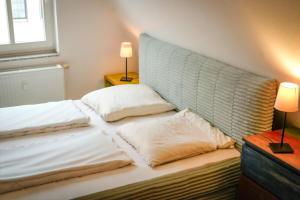 a bed with two pillows on it in a room at Ostsee43 - Apartment Ole in Rostock