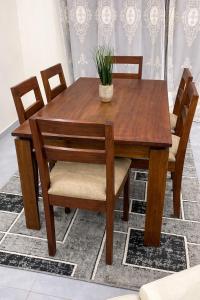 a wooden table and chairs with a plant on it at Villa Amani in Somone