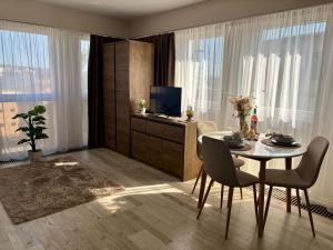 a living room with a table with chairs and a television at HelloWine Apartman III in Eger