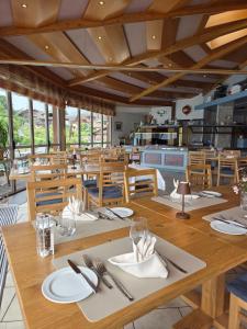 a dining room with wooden tables and chairs at Hotel Strandhotel in Iseltwald