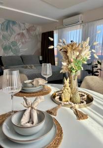 a dining room table with plates and flowers on it at HelloWine Apartman III in Eger