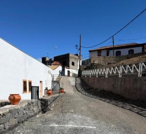 an alley way with a white building and some pots at Nature in Tejeda 2 in Tejeda