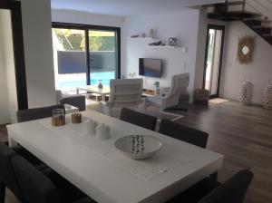 a living room with a white table and chairs at Villa Lisbonne piscine plage in Aroeira