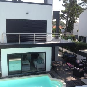 a house with a balcony with a swimming pool at Villa Lisbonne piscine plage in Aroeira