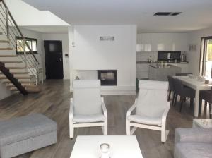 a living room with a couch and chairs and a fireplace at Villa Lisbonne piscine plage in Aroeira