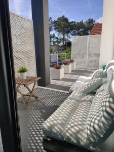 a couch sitting on a balcony with a table at Villa Lisbonne piscine plage in Aroeira