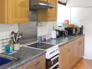 a kitchen with a sink and a stove top oven at The Cottage in Gosforth +21 photos