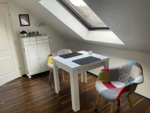 a white table and chairs in a kitchen with a skylight at Emma in Oberhausen +4 photos