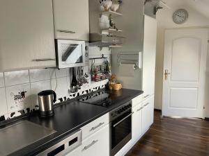 a kitchen with white cabinets and a black counter top at Emma in Oberhausen