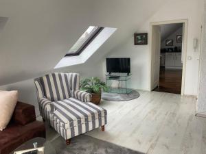 a living room with a chair and a tv at Emma in Oberhausen