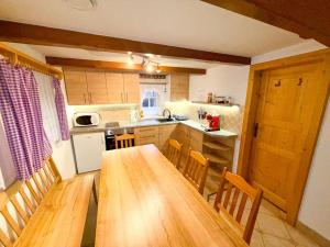 a kitchen with a long wooden table and chairs at Roprachtická chalupa in Roprachtice