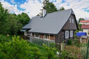 a black house with a gray roof at Roprachtická chalupa in Roprachtice