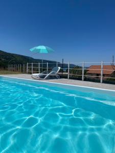 a swimming pool with a chair and an umbrella at A crita suite in Zambrone