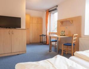 a room with a bed and a table and chairs at Altes Posthaus Ahlhorn in Großenkneten