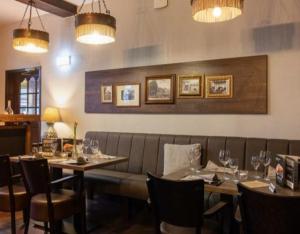 a restaurant with a couch and tables and wine glasses at Altes Posthaus Ahlhorn in Großenkneten