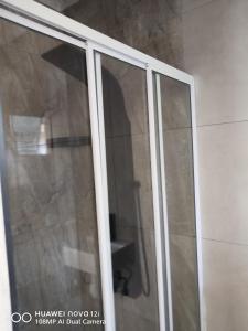 a shower with a glass door in a bathroom at Springbok Guest house in Mandini