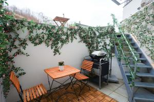a small patio with a table and a grill on a stairs at FeWo JoJo am Luegsteinsee mit traumhaftem Kaiserblick in Kiefersfelden +24 photos