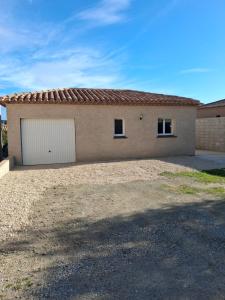 a house with a garage in a yard at Maison du causse in Magalas