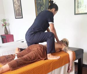 a woman sitting on a bed with a woman standing on top at Emerald Angkor Siem Reap in Siem Reap