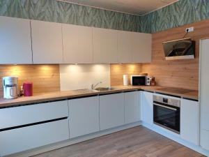 a kitchen with white cabinets and a sink at Ferienwohnung am Drömling Südheide - Gerda in Bergfeld