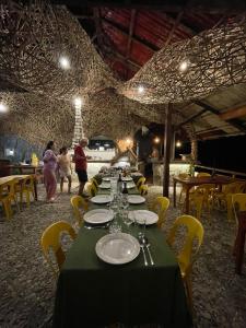 a long table with a green table cloth and yellow chairs at 74YOU Beach Resort and Restaurant in Puerto Princesa City