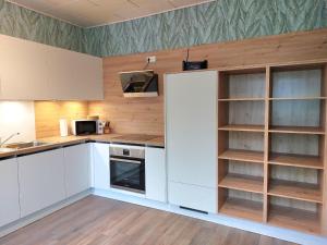a kitchen with white cabinets and wooden shelves at Ferienwohnung am Drömling Südheide - Gerda in Bergfeld